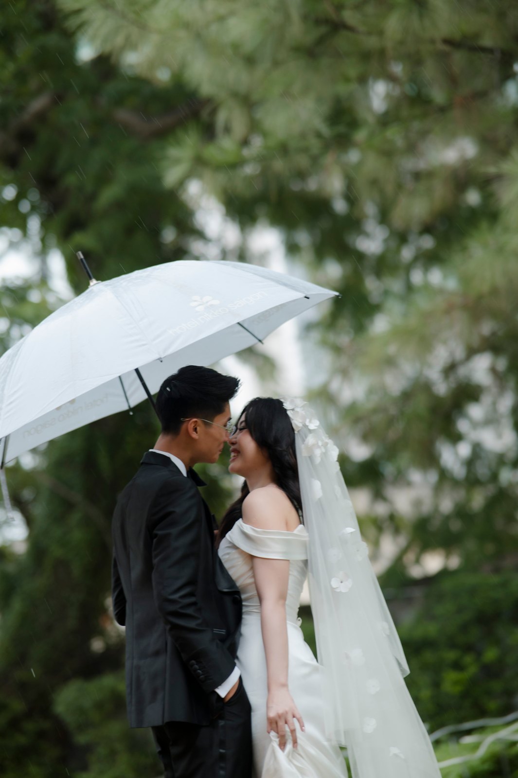Đôi uyên ương kề sát bên nhau dưới ô trong suốt giữa cơn mưa lất phất