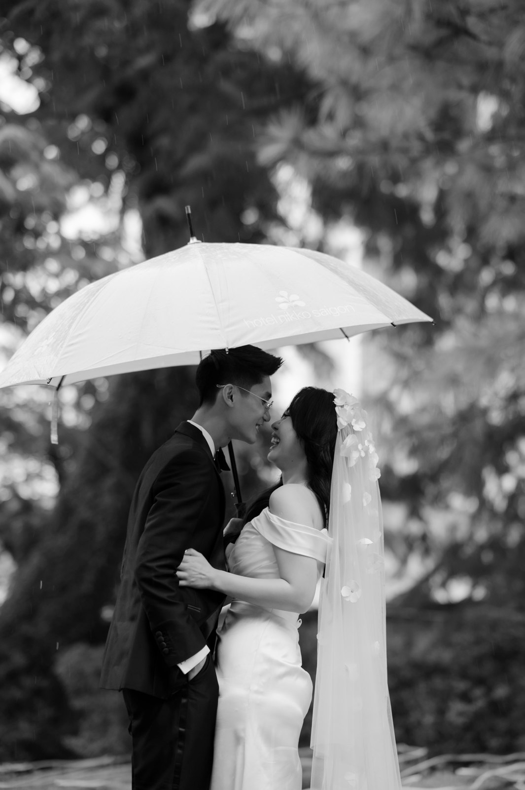 Cô dâu chú rể che chung chiếc ô trong suốt giữa làn mưa, ảnh trắng đen