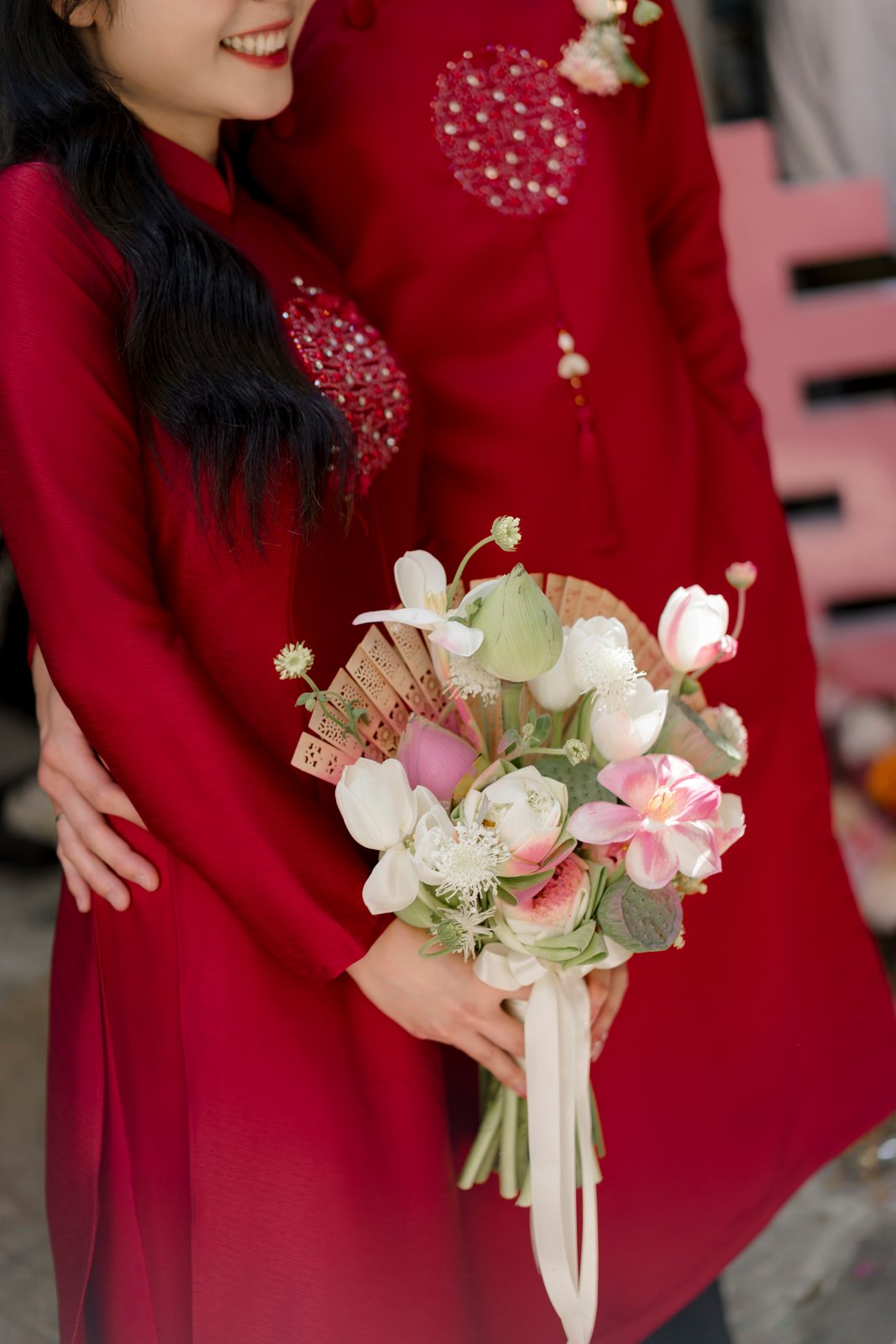 Cô dâu chú rể áo dài đỏ cùng cầm bó hoa sen trong lễ ăn hỏi truyền thống