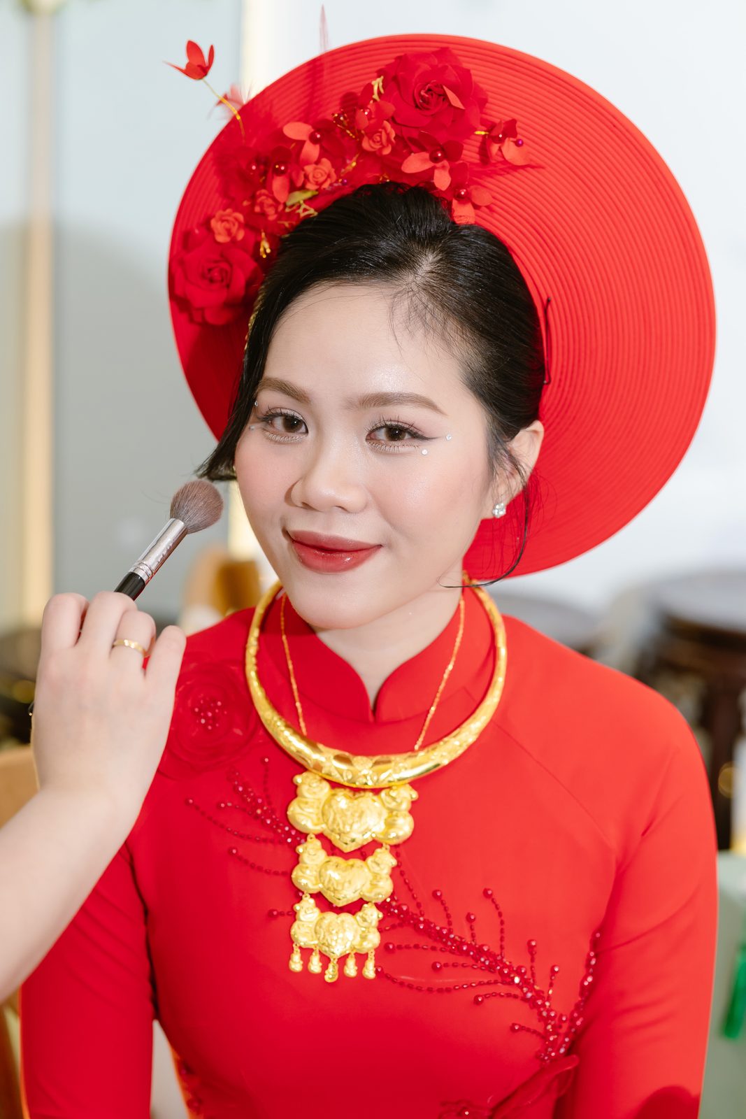 Cô dâu Ngọc Nhung trong áo dài đỏ và mấn được trang điểm trước giờ làm lễ