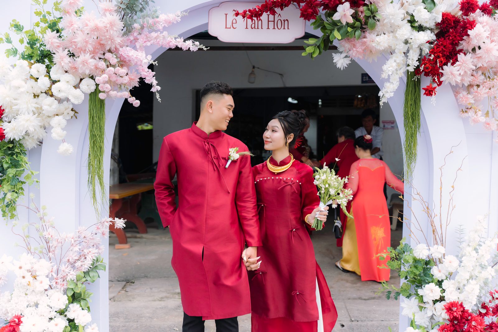 Cô dâu chú rể bước qua cổng hoa Lễ Tân Hôn tại nhà trai